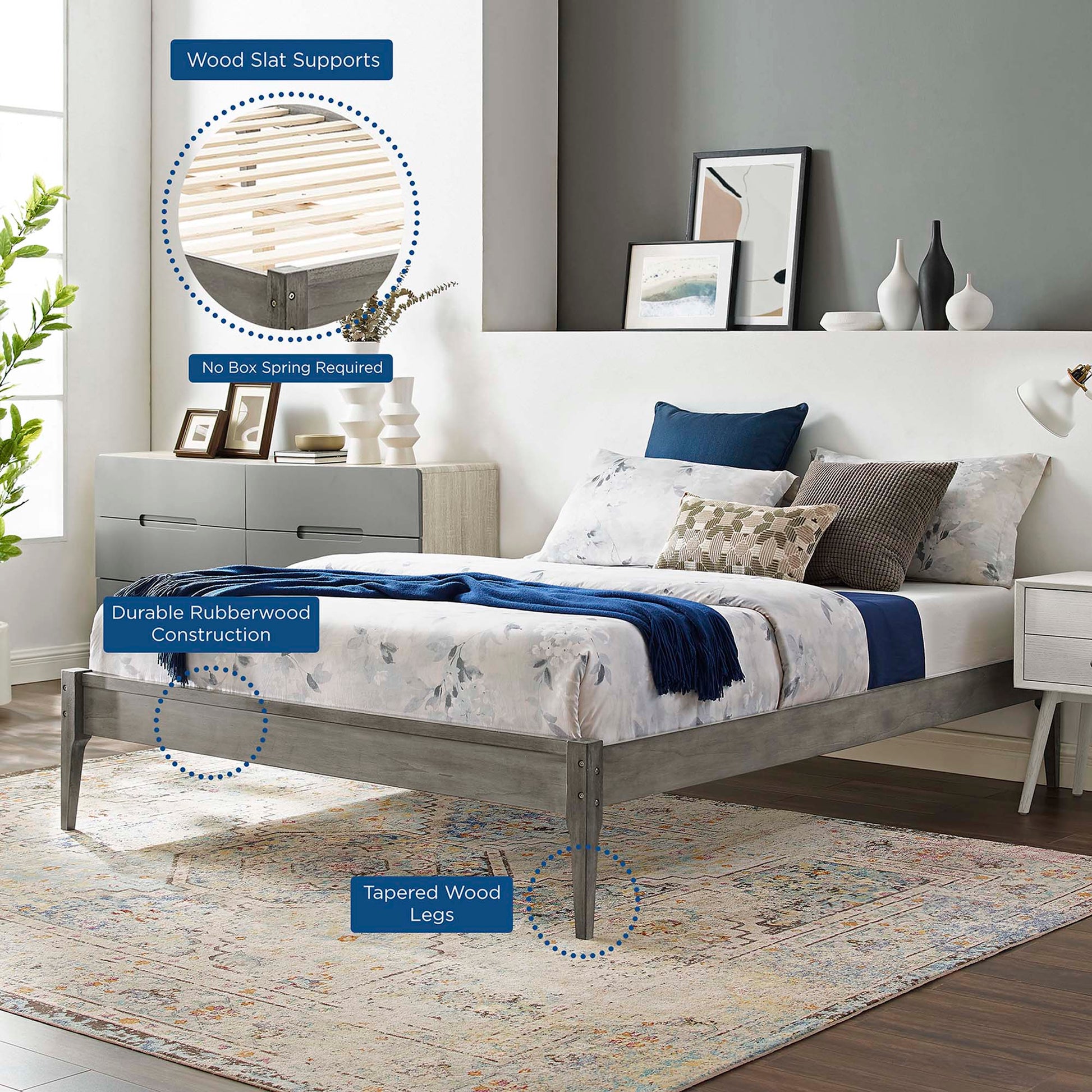 Gray rubberwood platform bed with tapered legs and wood slat supports in a modern bedroom, blue and white bedding.