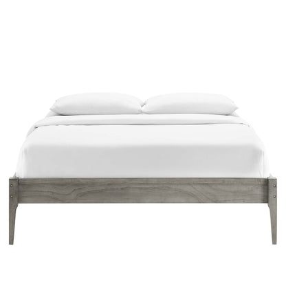 Weathered gray wood platform bed with white bedding and two pillows; low-profile rustic farmhouse style.