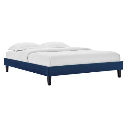 Navy blue upholstered platform bed with low-profile frame and tapered legs, white bedding and two pillows.