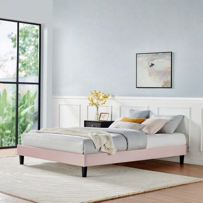 Pink upholstered platform bed with gray bedding and cream throw in a bright modern bedroom with white paneling and a rug.