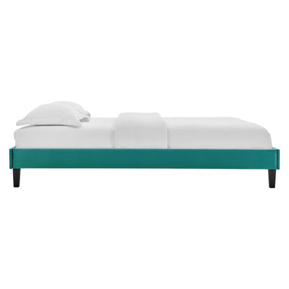 Teal upholstered platform bed frame with black tapered legs, white mattress and pillows.