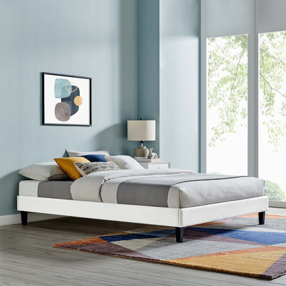 White upholstered full platform bed frame with gray bedding, yellow accent pillow, abstract art & colorful area rug.