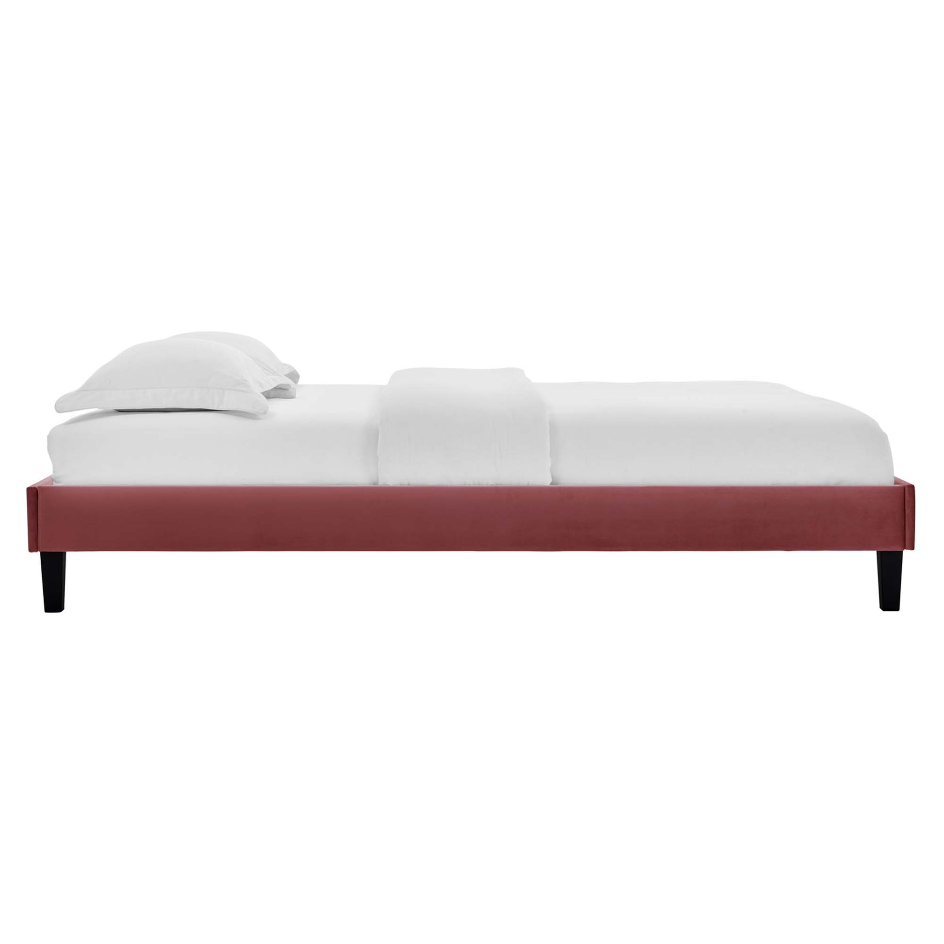 Red velvet queen platform bed with a low-profile frame and white linens.