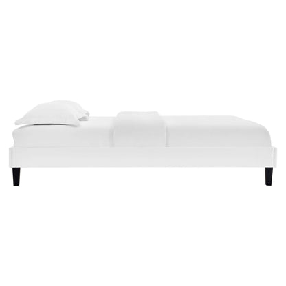 White upholstered modern platform bed with black tapered legs and crisp white bedding.
