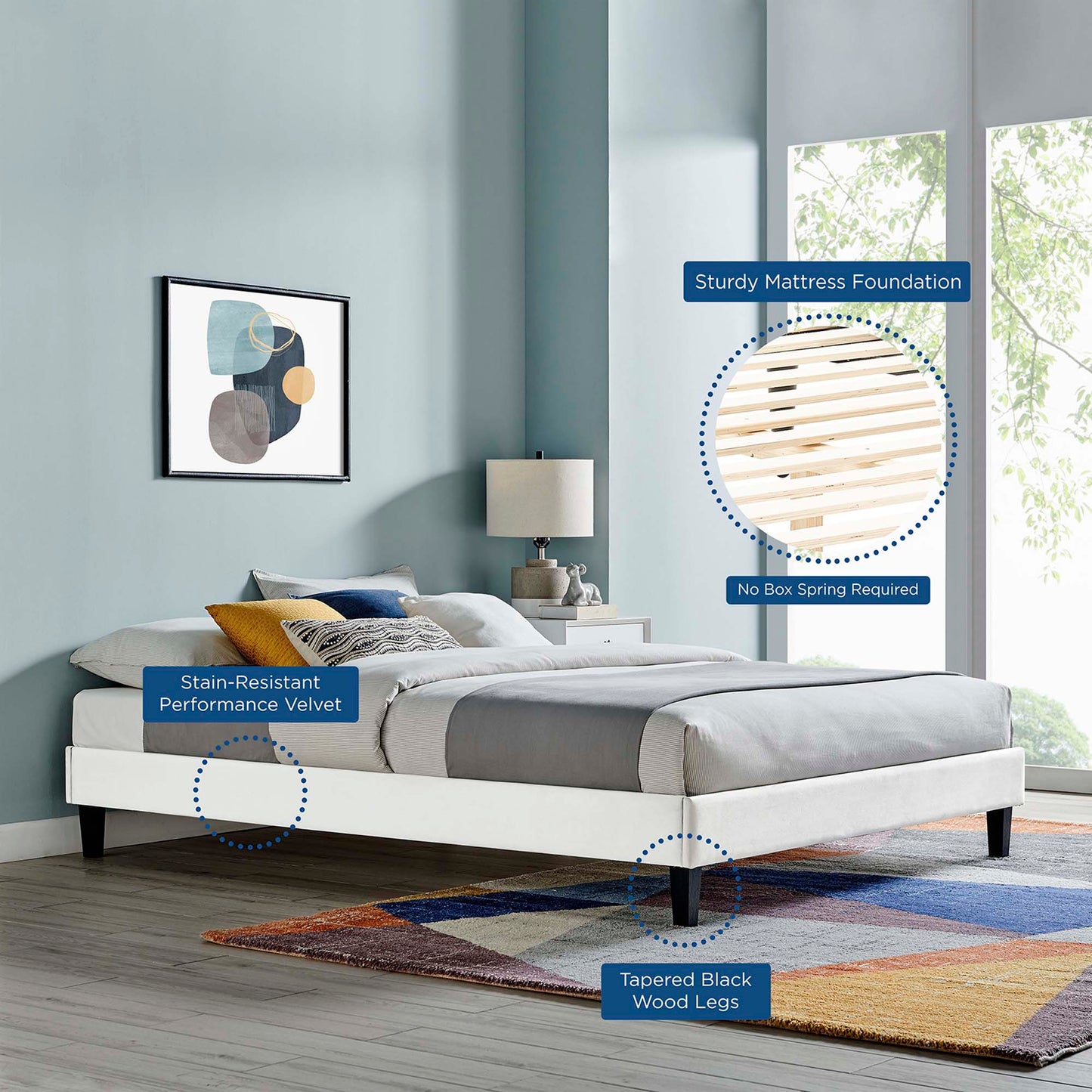 White upholstered platform bed with stain-resistant velvet, tapered black wood legs in a modern minimalist bedroom.