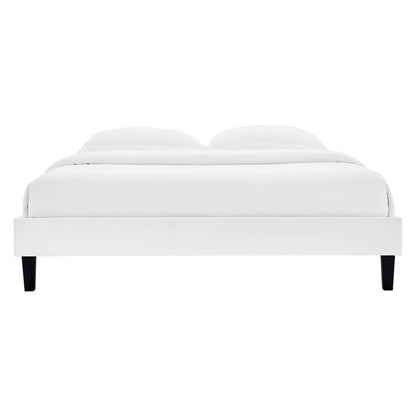 White platform bed with low frame, white duvet & pillows, and black tapered legs.