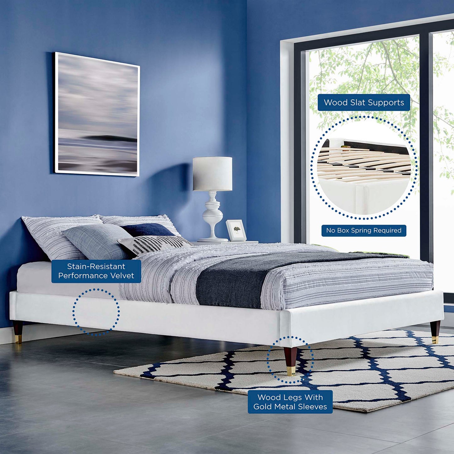 White upholstered full platform bed frame with stain-resistant velvet, wood legs with gold sleeves, blue-gray bedding in a blue bedroom.