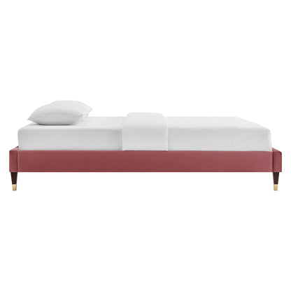 Red upholstered queen platform bed frame with gold-tipped legs, white mattress, pillow and center white throw; modern style.