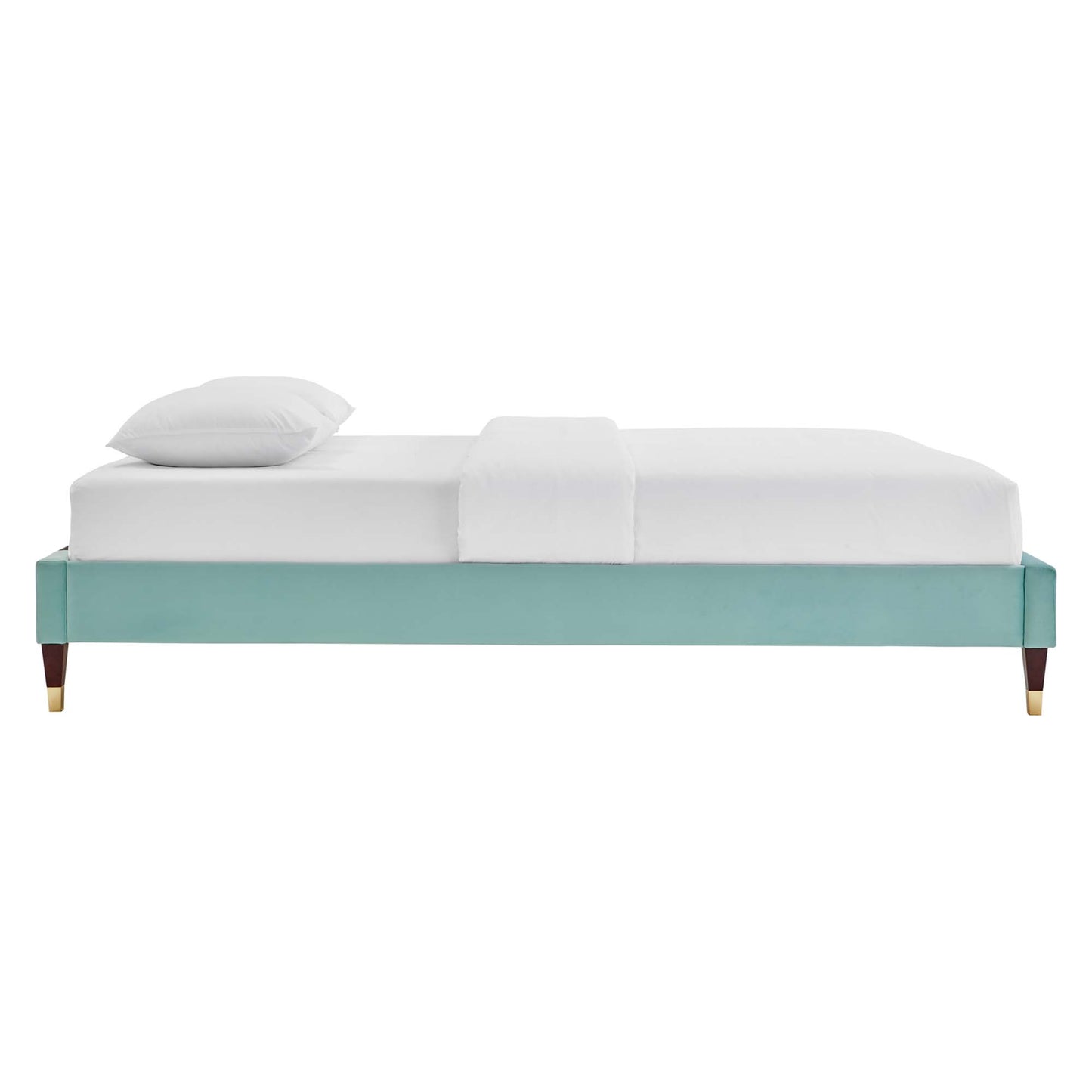 Mint green upholstered platform bed frame with tapered wooden legs and brass caps, white bedding.