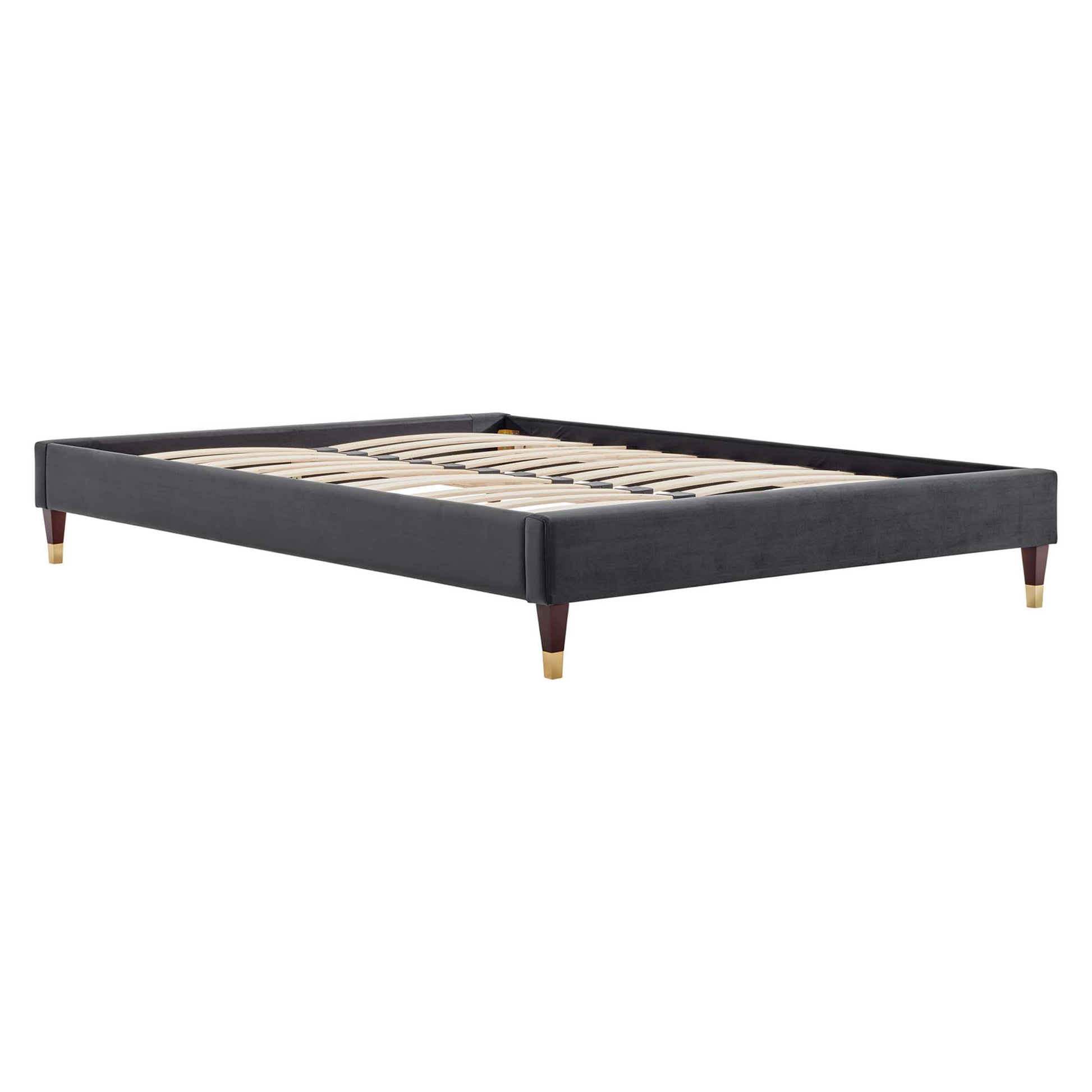 Low-profile charcoal gray upholstered king platform bed frame with wooden slats and tapered legs with brass caps.