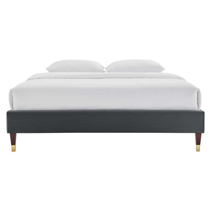 Charcoal velvet platform bed frame with gold-tipped legs and white bedding