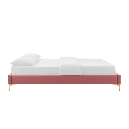 Dusty-rose upholstered platform bed with slim gold legs & white bedding.