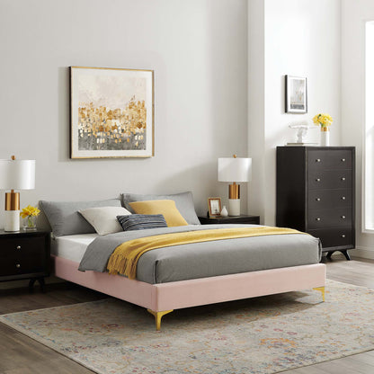 Red upholstered queen bed frame with gray bedding and a yellow throw, black nightstands, gold-accent lamps, and a tall dresser.