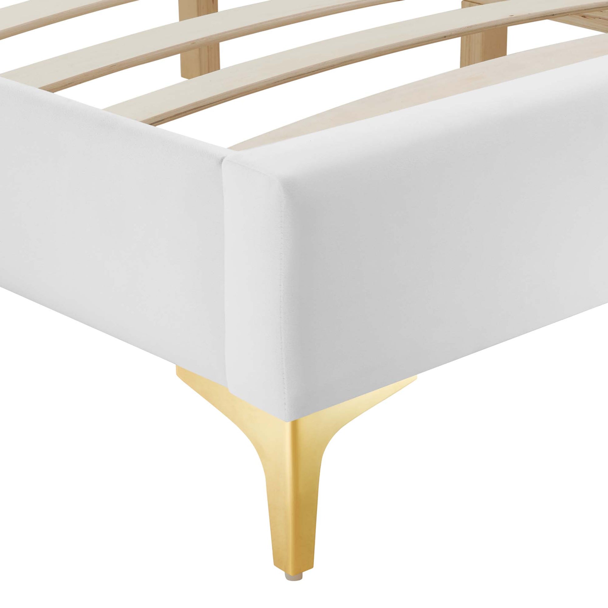 White upholstered bed frame corner with gold tapered leg and wooden slats.