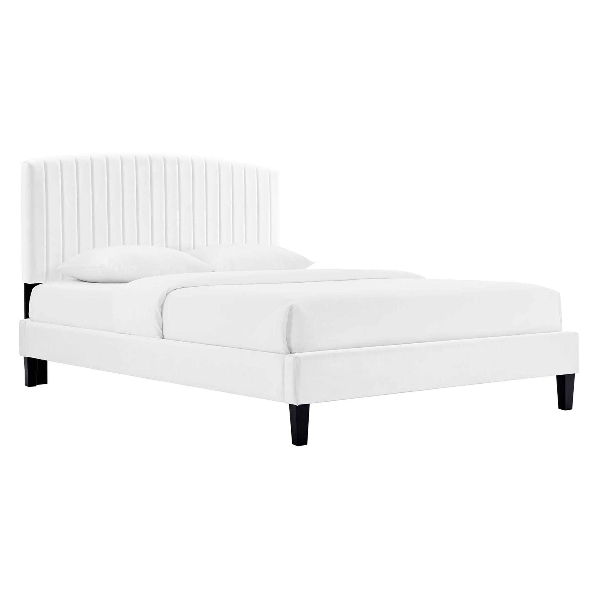 White upholstered platform bed with tall vertical-channel headboard, cushioned frame, black tapered legs, and two pillows.