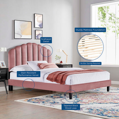 Red velvet upholstered platform bed with scalloped headboard, tapered black wood legs, and slatted foundation.