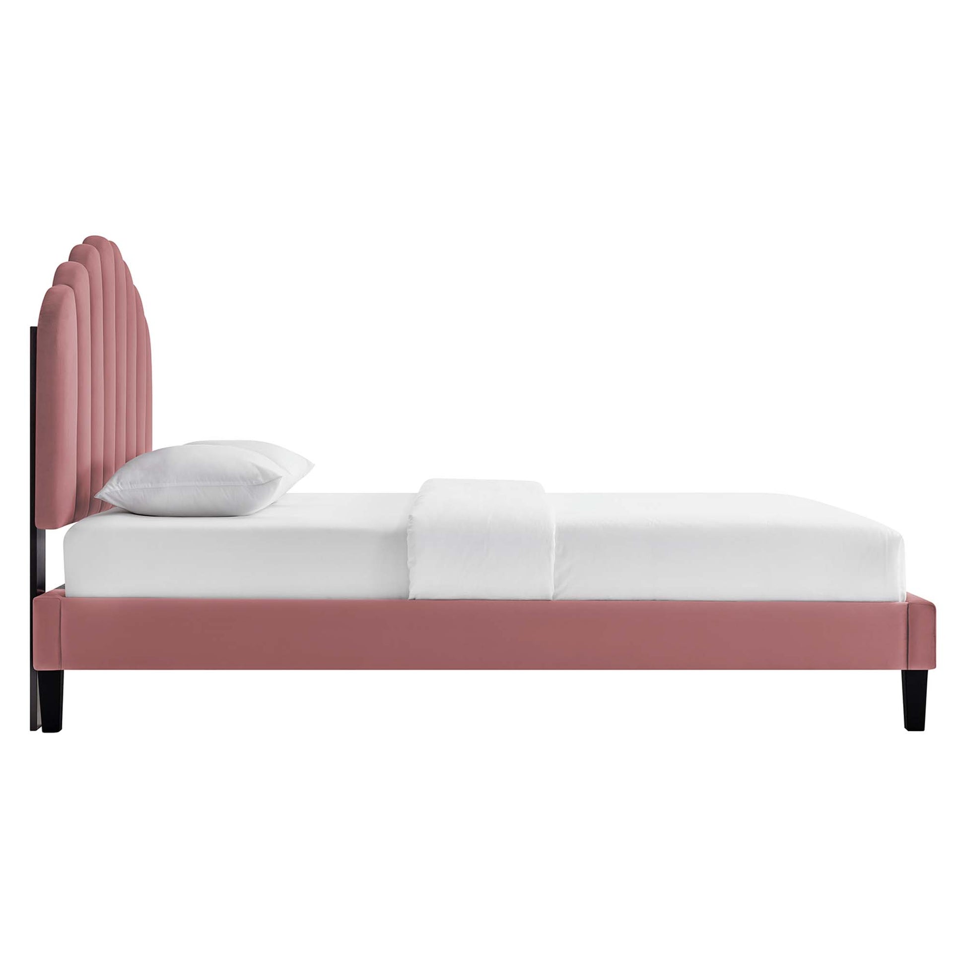 Red velvet bed with tall, arched, vertical-tufted headboard, white bedding, red frame and black legs.