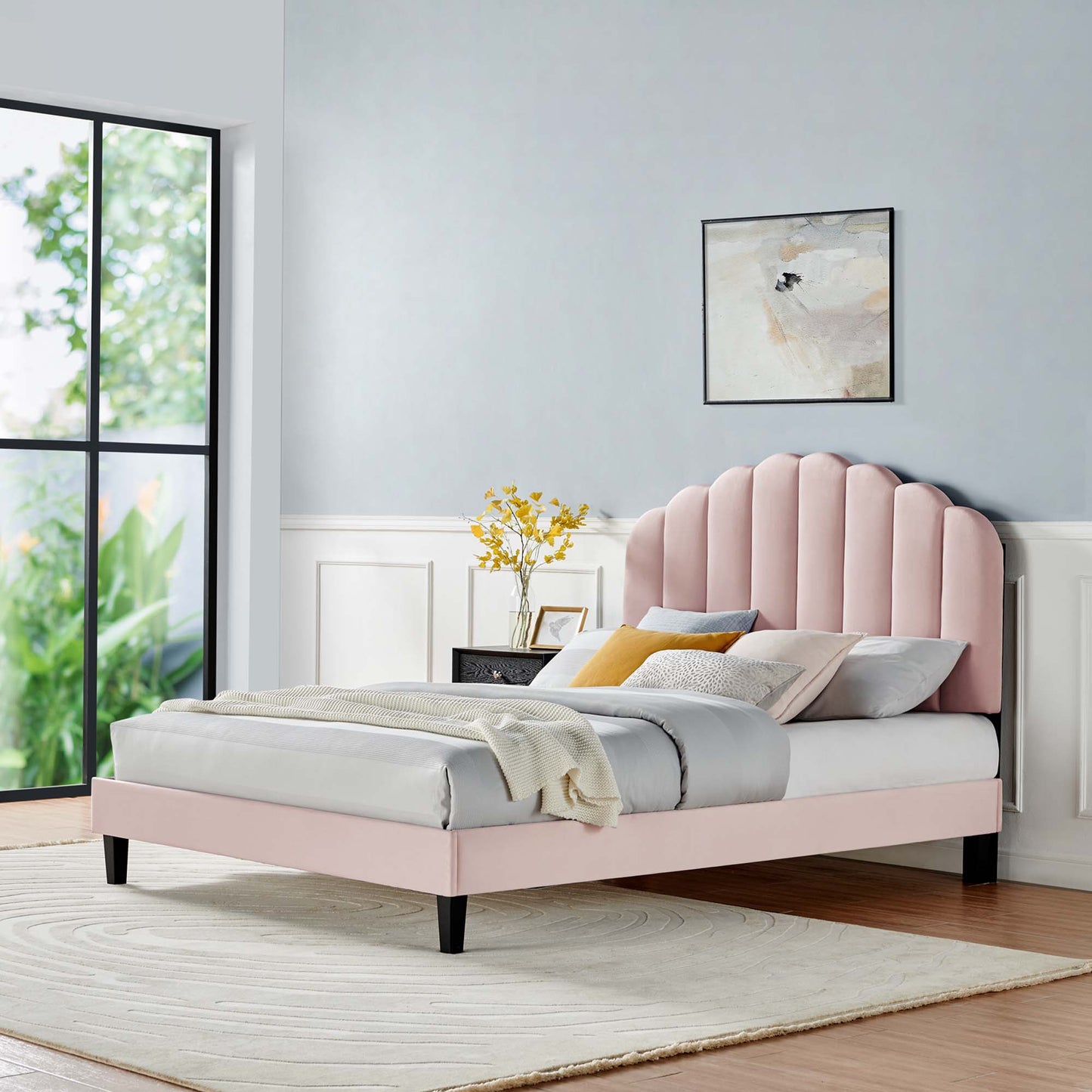 Pastel pink bed with scalloped headboard, white bedding, yellow and gray cushions in a light blue bedroom.