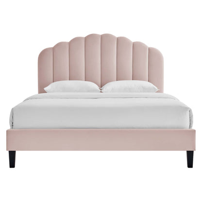 Soft pink upholstered platform bed with scalloped arched headboard, white bedding, black tapered legs.