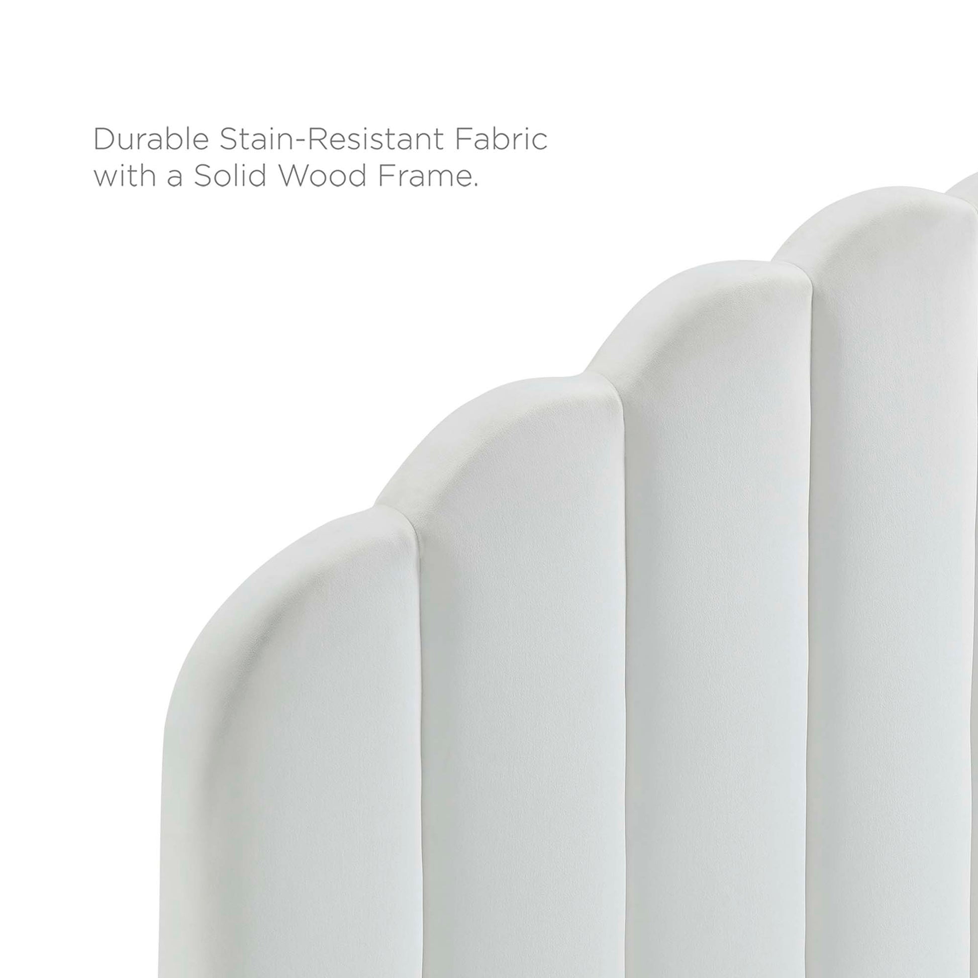 White upholstered headboard with curved vertical panels on a solid wood platform bed frame.