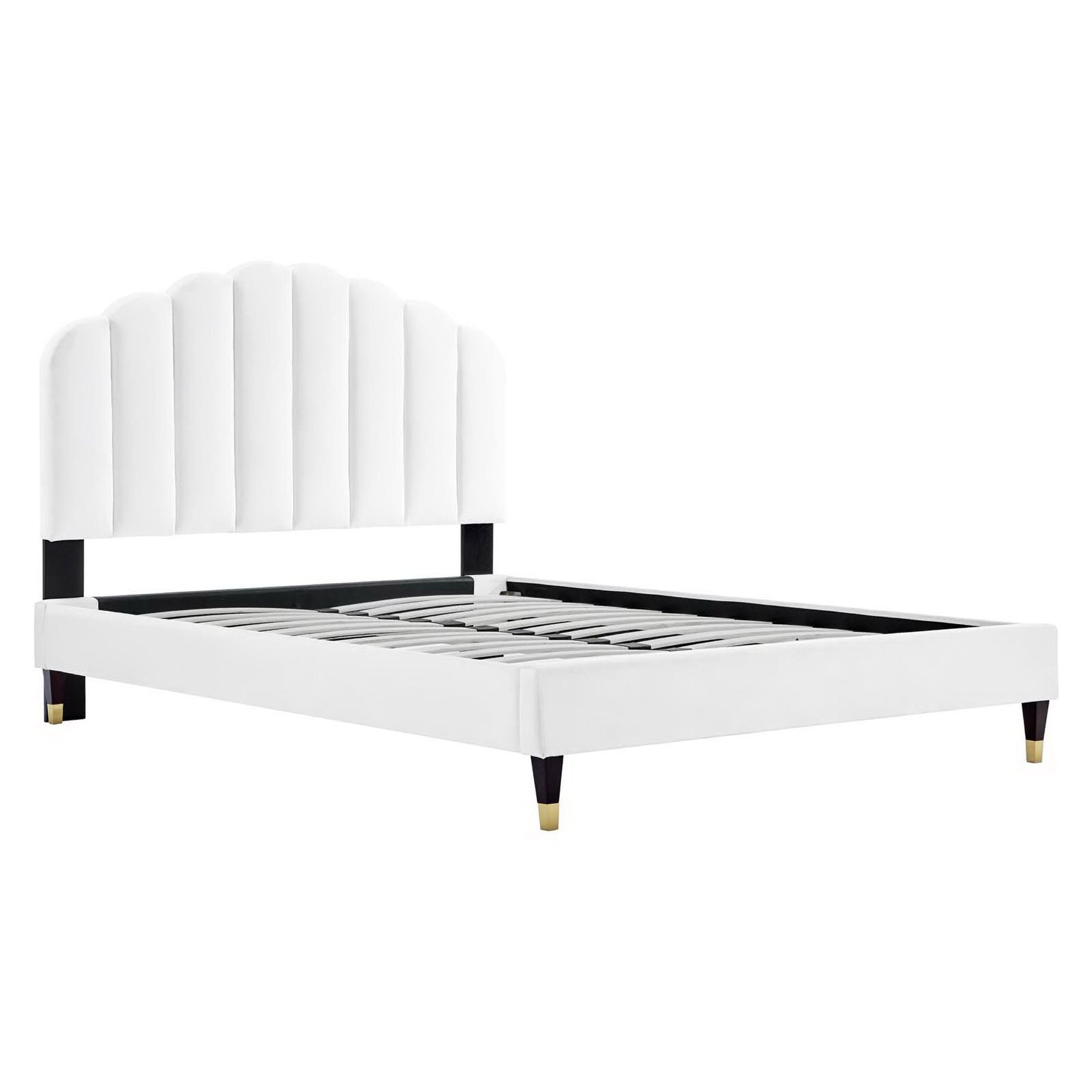 White upholstered platform bed with a scalloped, arched headboard, black supports, and brass-tipped legs.