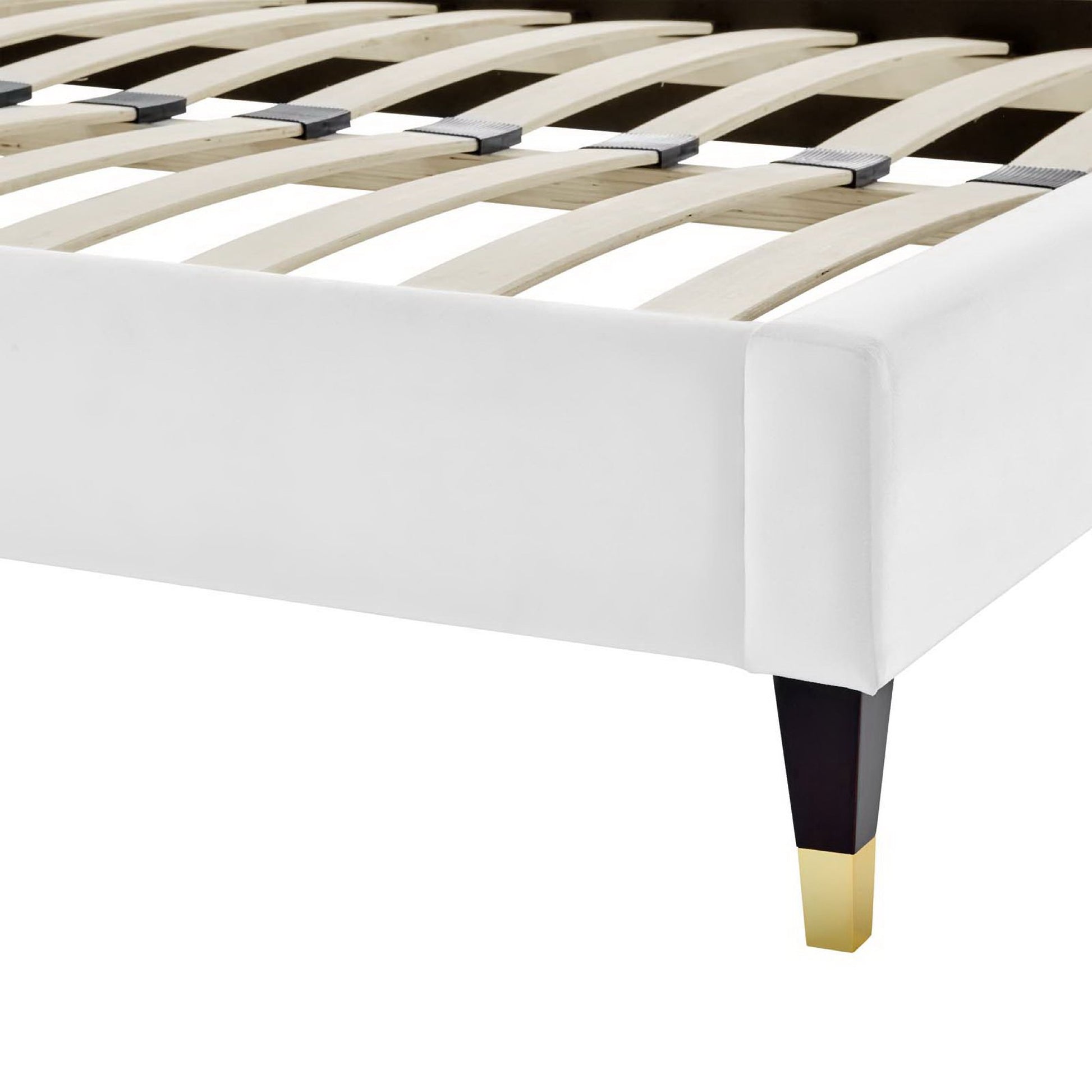 White upholstered queen platform bed with light wood slat base and dark tapered legs with gold caps.