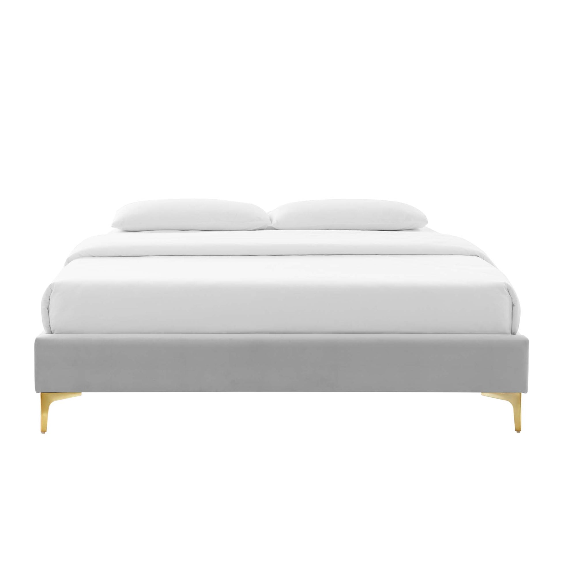 Light gray upholstered platform bed with white bedding and gold legs