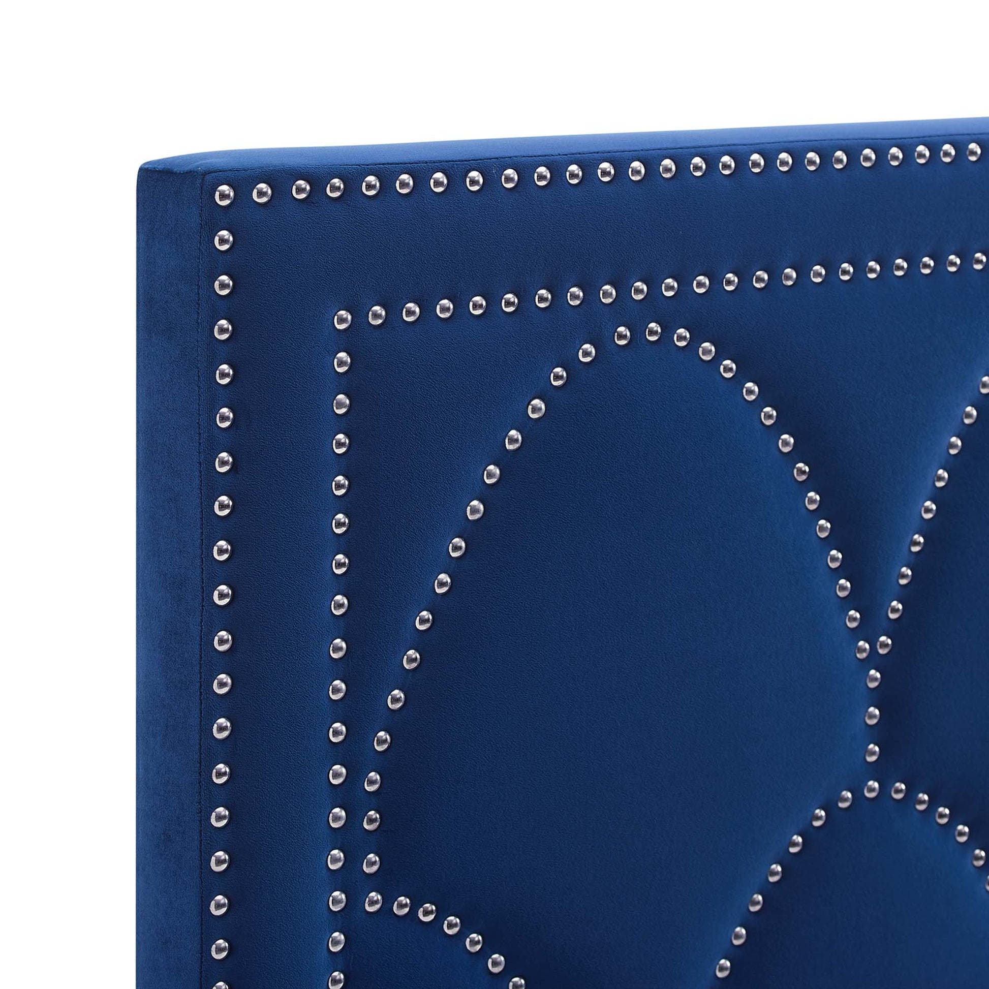 Navy velvet headboard panel with silver nailhead trim outlining geometric shapes.