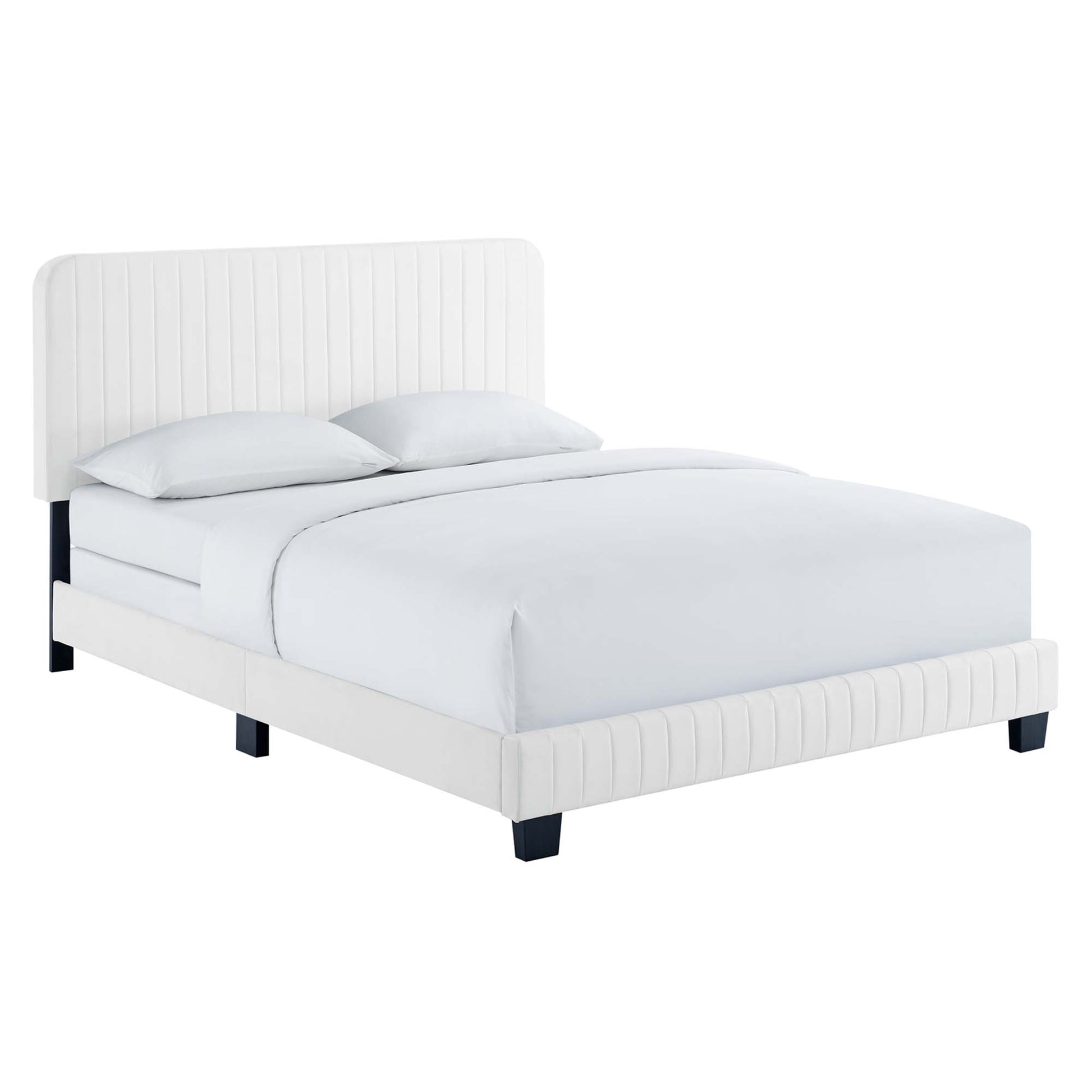 White velvet upholstered king bed with a tall channel-tufted headboard, dark cube legs and white bedding.