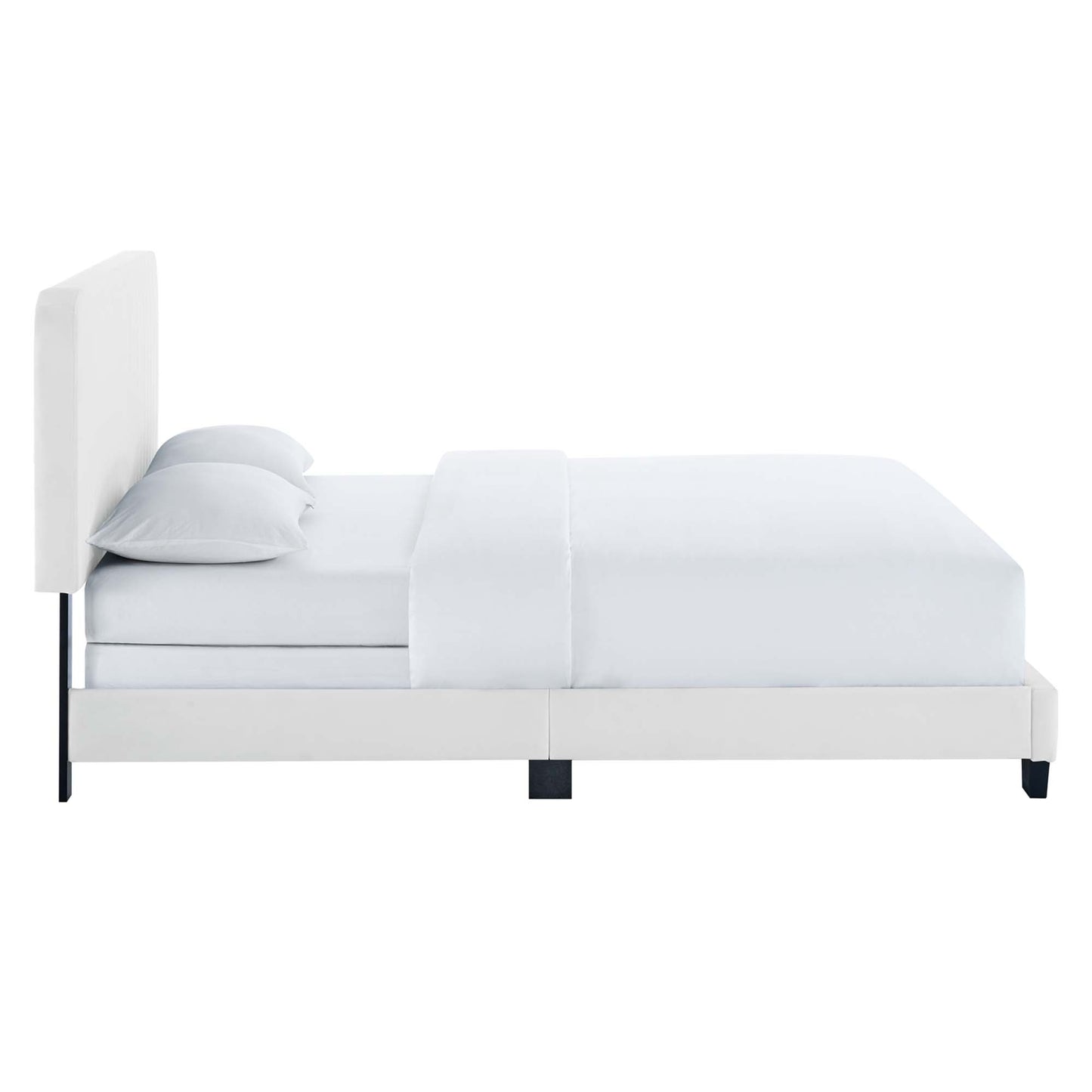White upholstered platform bed with tall padded headboard, white bedding and black low legs.