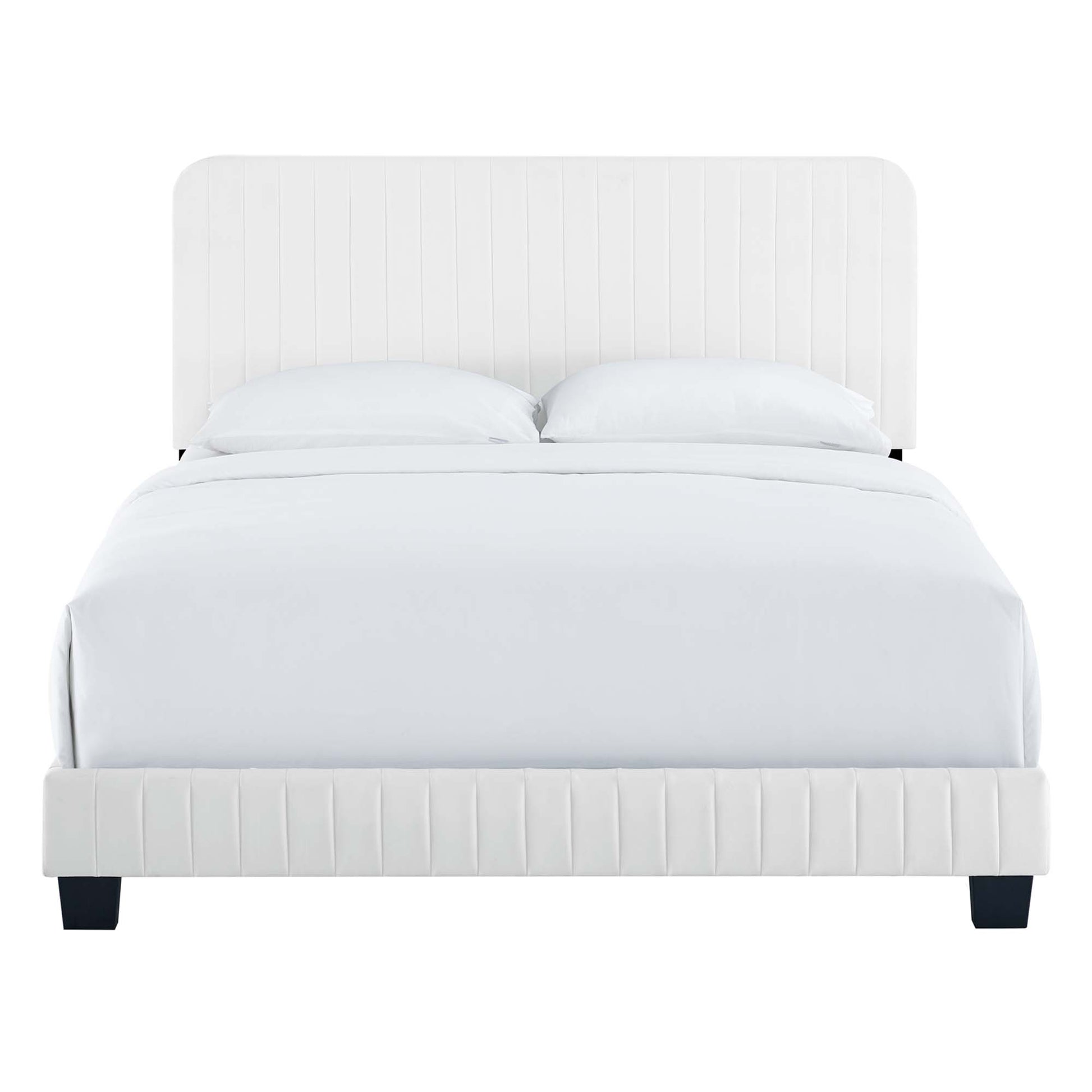 White upholstered king bed with vertical channel-tufted headboard and footboard, white bedding, dark square feet.