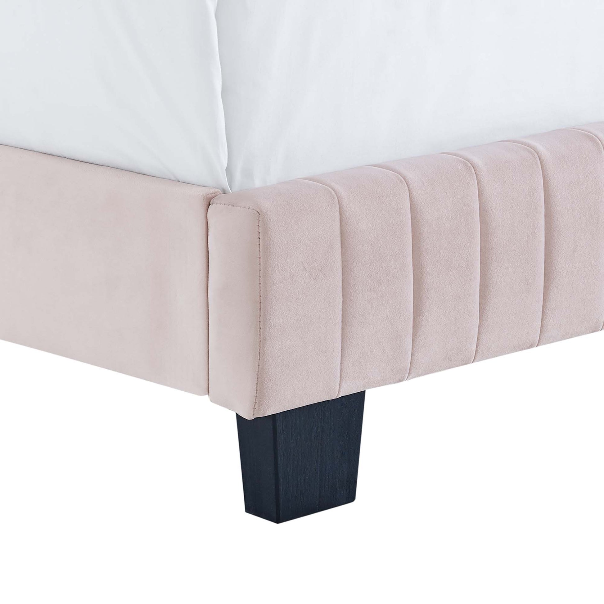 Blush pink velvet queen bed with vertical channel tufting on the headboard and dark square wood legs.