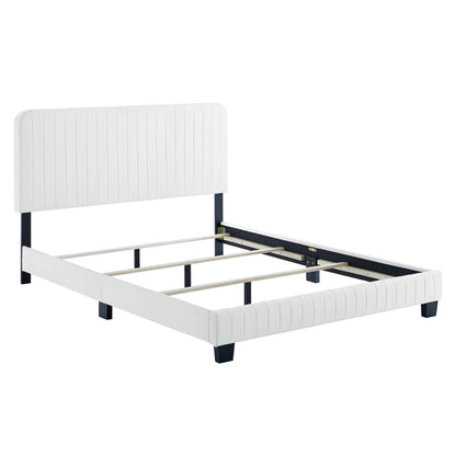White upholstered queen bed with tall padded headboard and footboard, navy rails, and wooden slats.