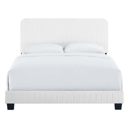 White upholstered bed with tall rounded headboard and vertical tufting, matching footboard, white bedding and pillows.