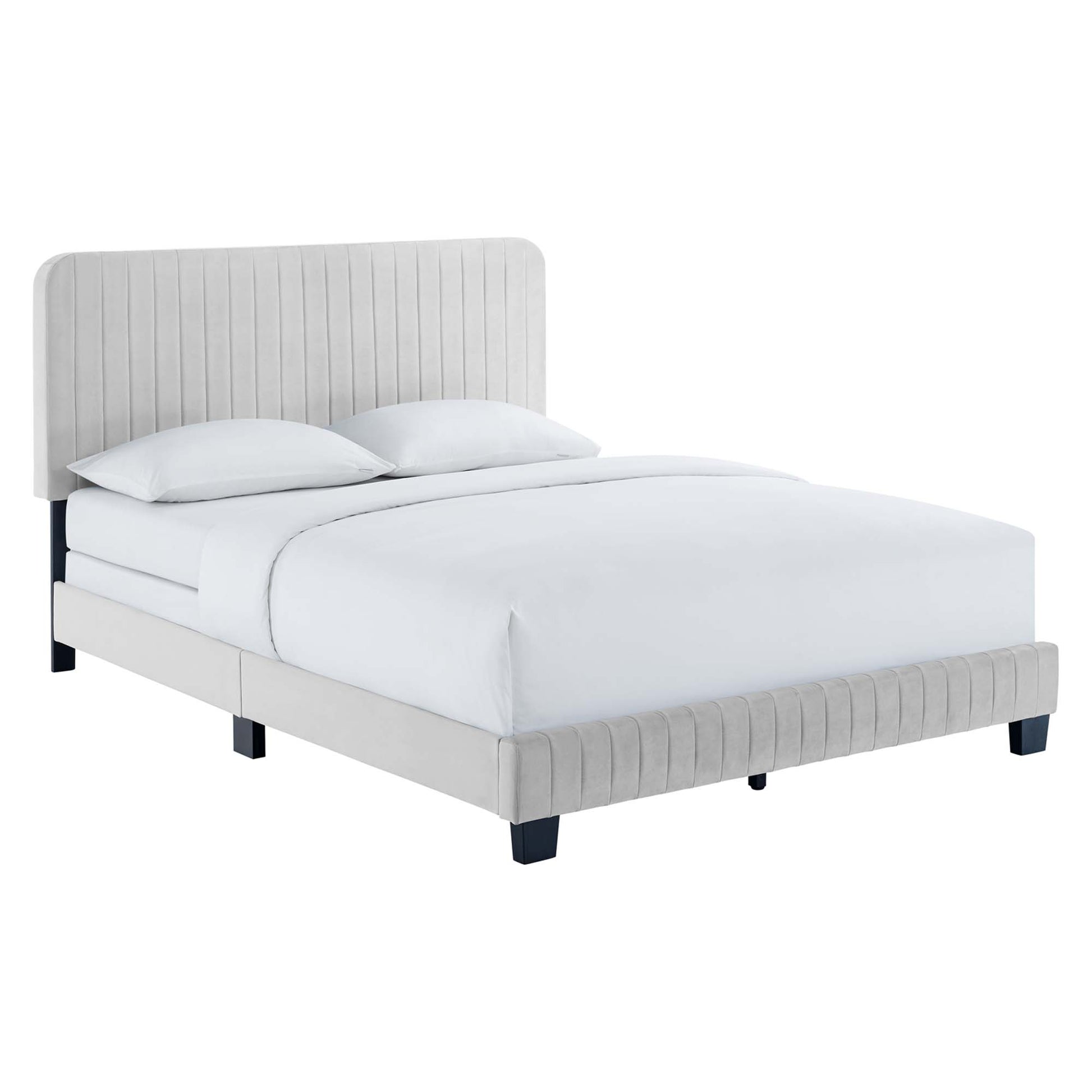 Light gray upholstered bed with tall vertical-stitched headboard, low platform frame, and white bedding.