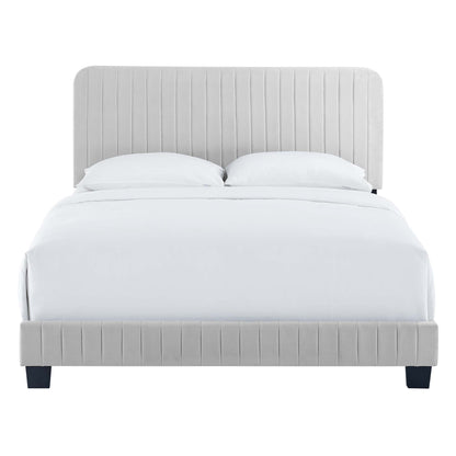 Light gray upholstered bed with vertical-channel headboard and footboard, white linens and dark legs.