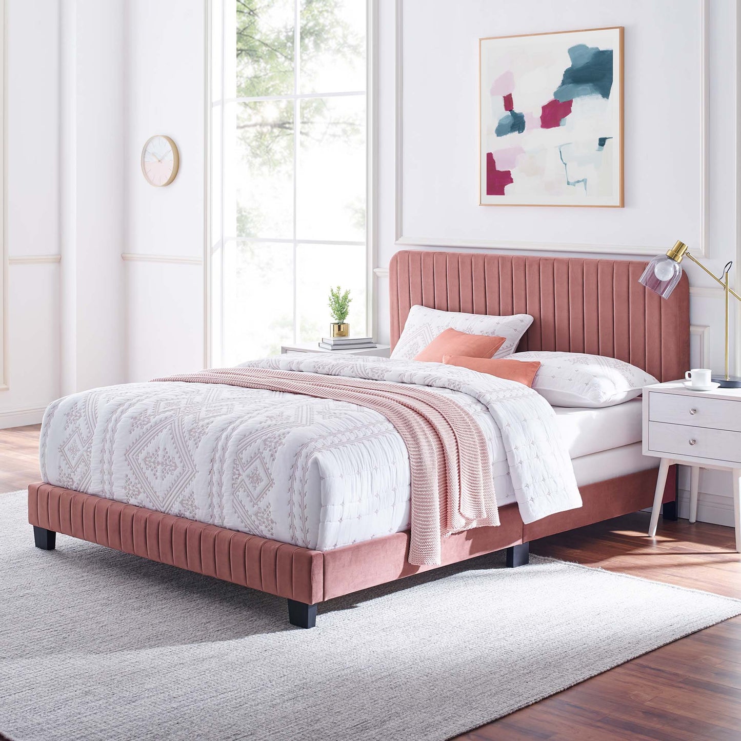 Red velvet twin bed with tufted headboard, white quilted bedding, blush throw, white nightstand, gold lamp, abstract wall art.
