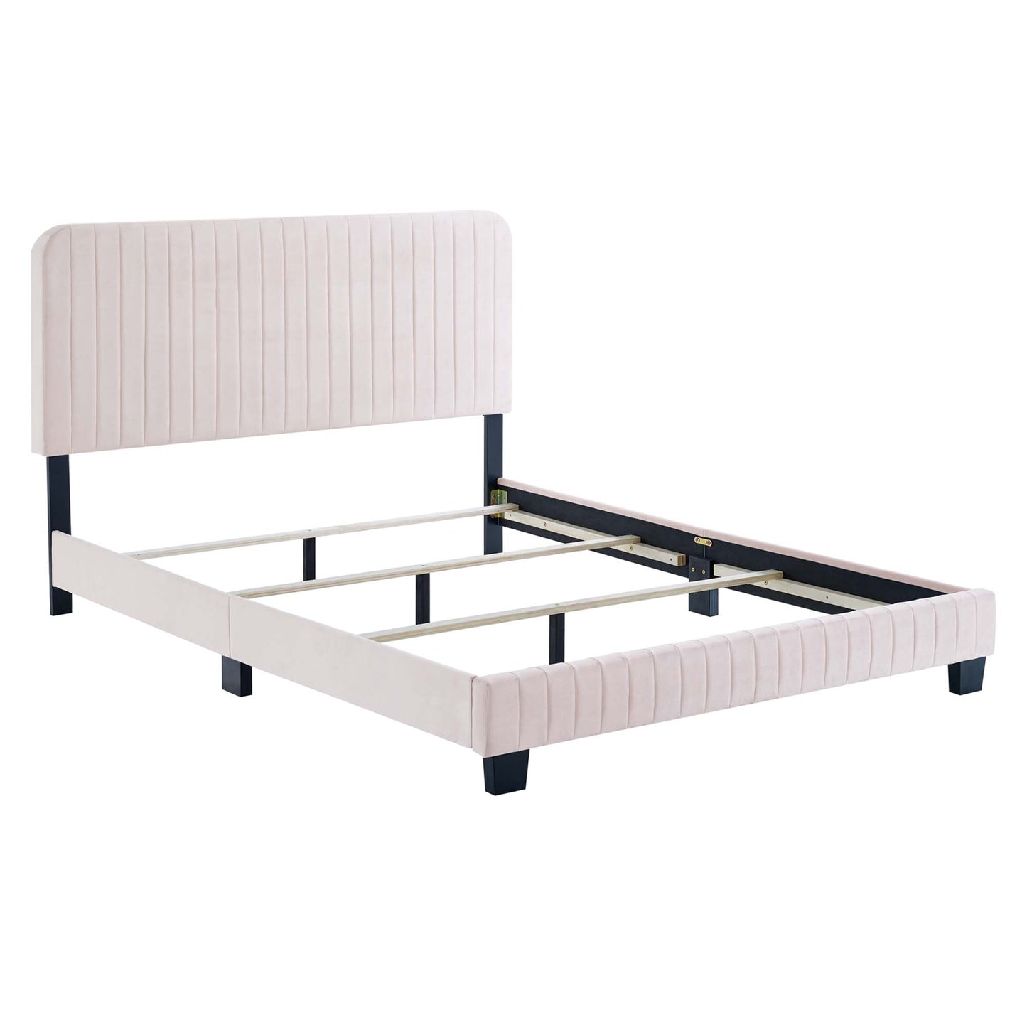 Blush pink upholstered platform bed with vertically tufted headboard and footboard, dark legs, light wood slats.