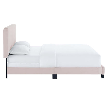 Blush pink upholstered twin bed with tall padded headboard, white bedding and two gray pillows.