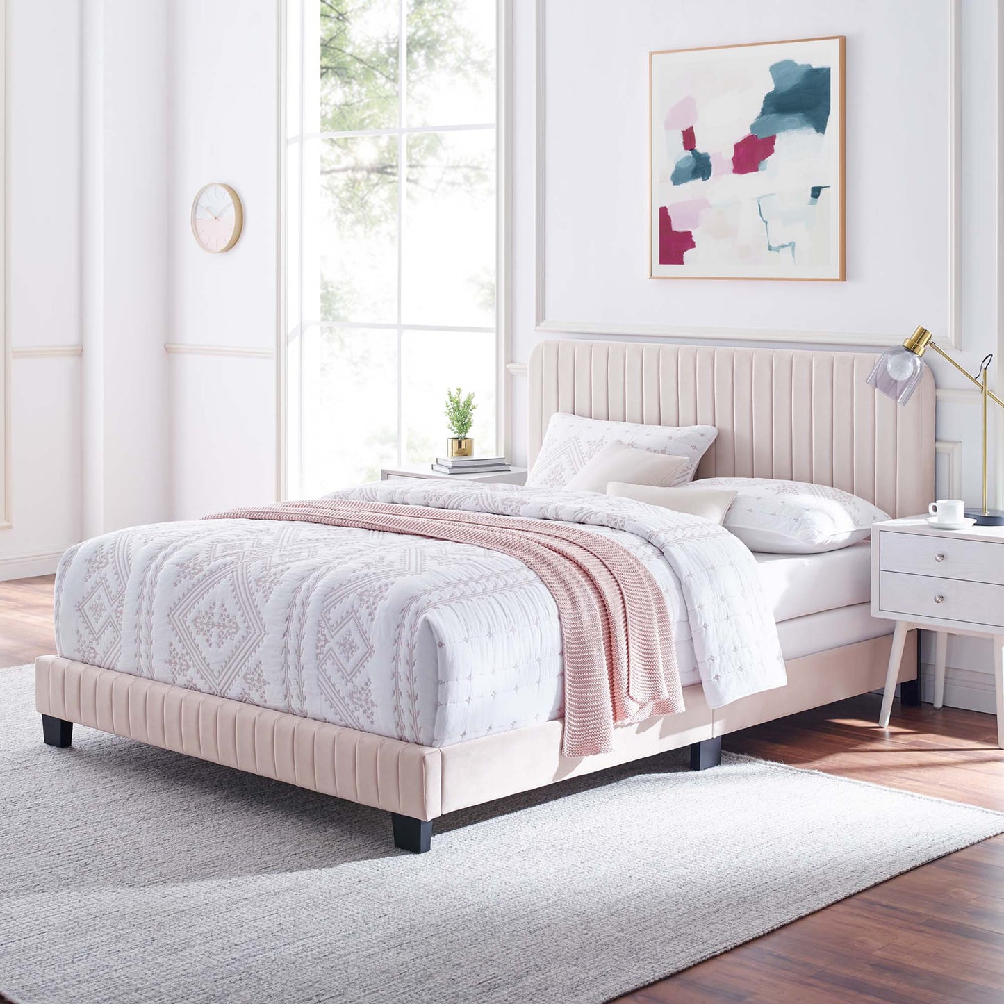 Red upholstered platform twin bed with tufted headboard in a modern bedroom, with a white geometric quilt and a blush knit throw.