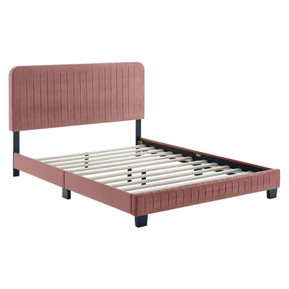 Red upholstered platform bed with a tall vertical channel-tufted headboard, black legs and a slatted base.