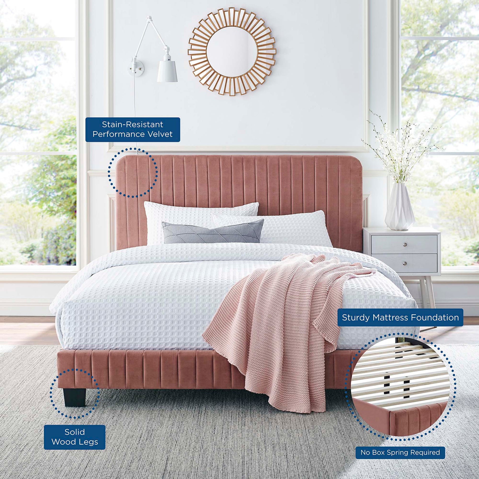 Red velvet upholstered queen platform bed with solid wood legs, white bedding, pink throw; sunburst mirror.