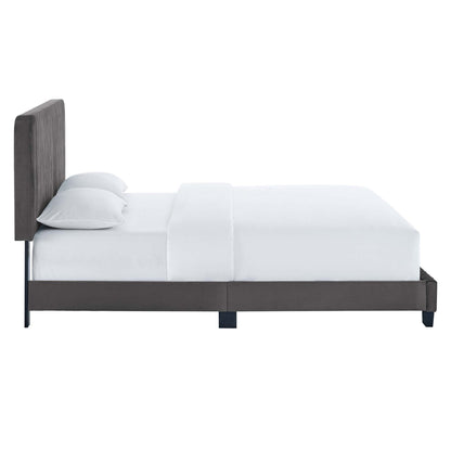 Gray upholstered platform bed with tall tufted headboard, white bedding, dark frame and legs.