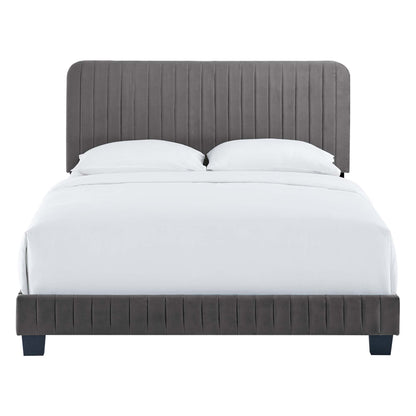 Grey upholstered platform bed with vertical channel tufting on headboard and footboard, white bedding, short dark legs.