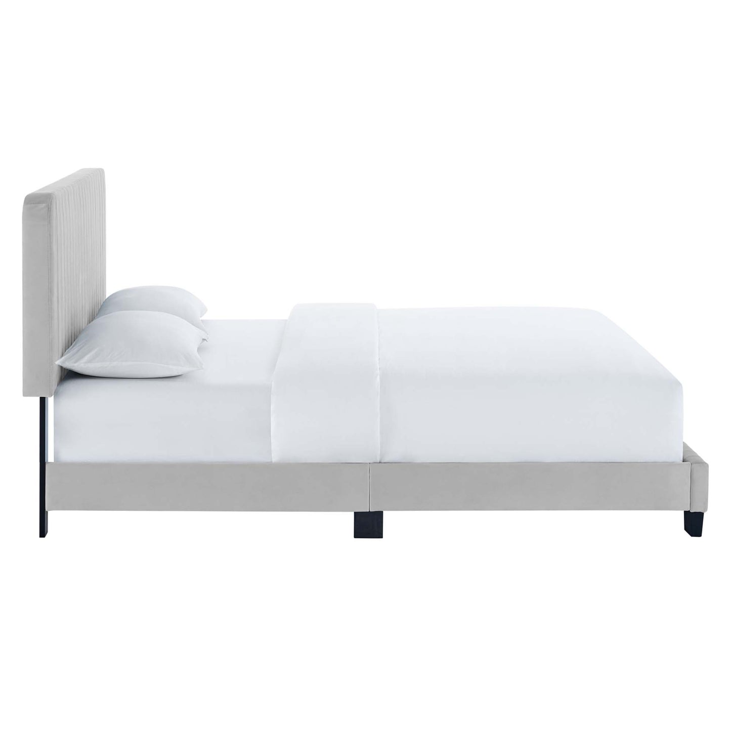 Gray upholstered platform bed with tall padded headboard, white bedding and pillows, slim black legs.
