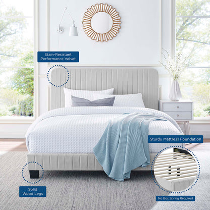 Light gray upholstered bed with channel-tufted headboard, solid wood legs, white bedding, blue throw, modern bedroom setup.