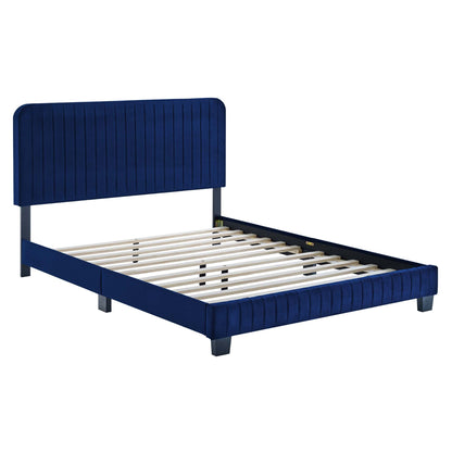 Navy blue upholstered platform bed with vertical channel tufting on headboard & footboard, metal legs, slatted base.