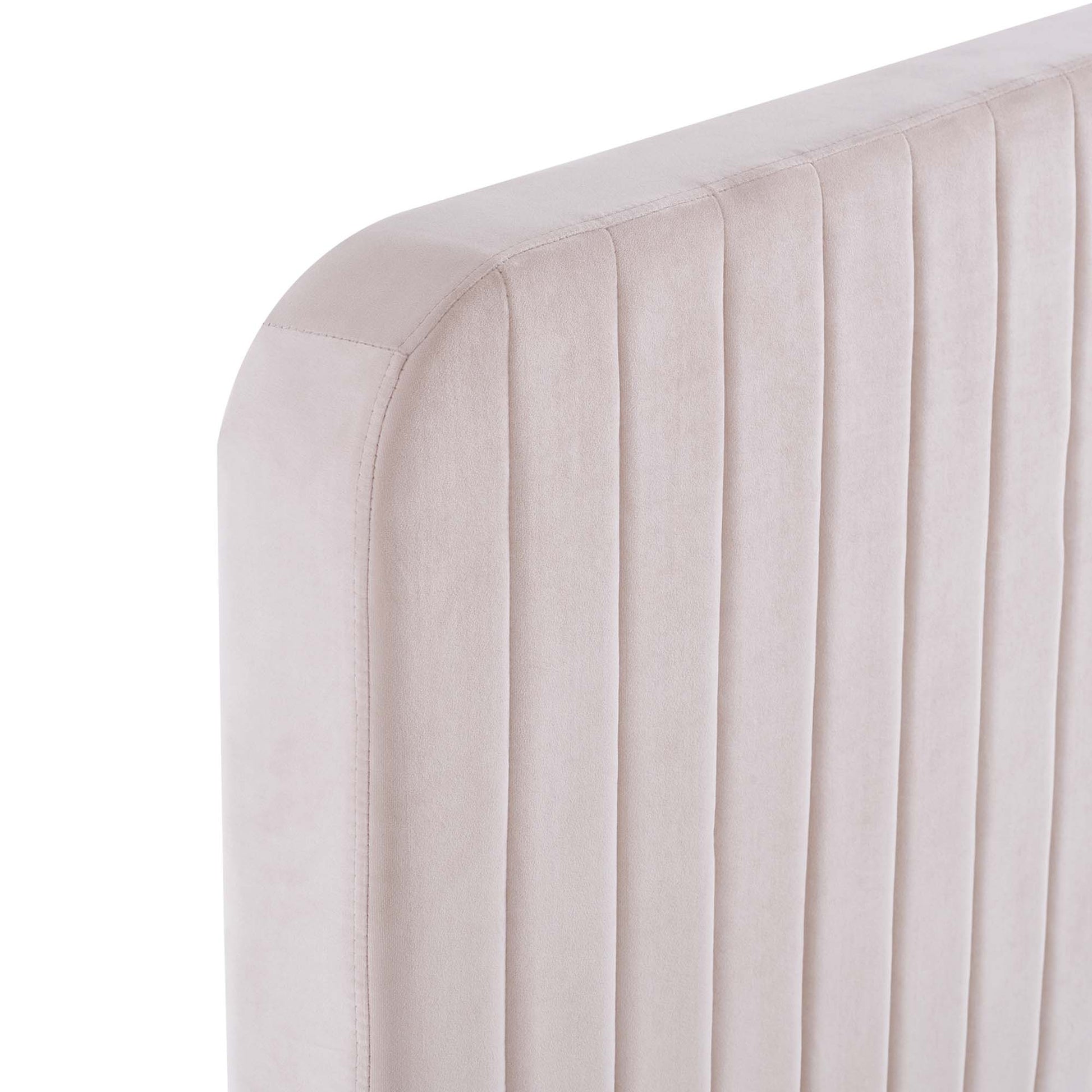Blush pink velvet upholstered bed headboard with vertical channel tufting and rounded corner.