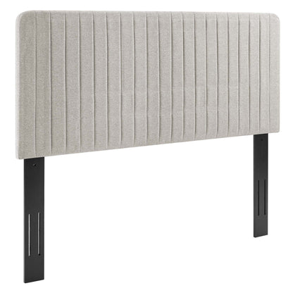 Oat fabric upholstered headboard with vertical channel tufting and black metal legs.