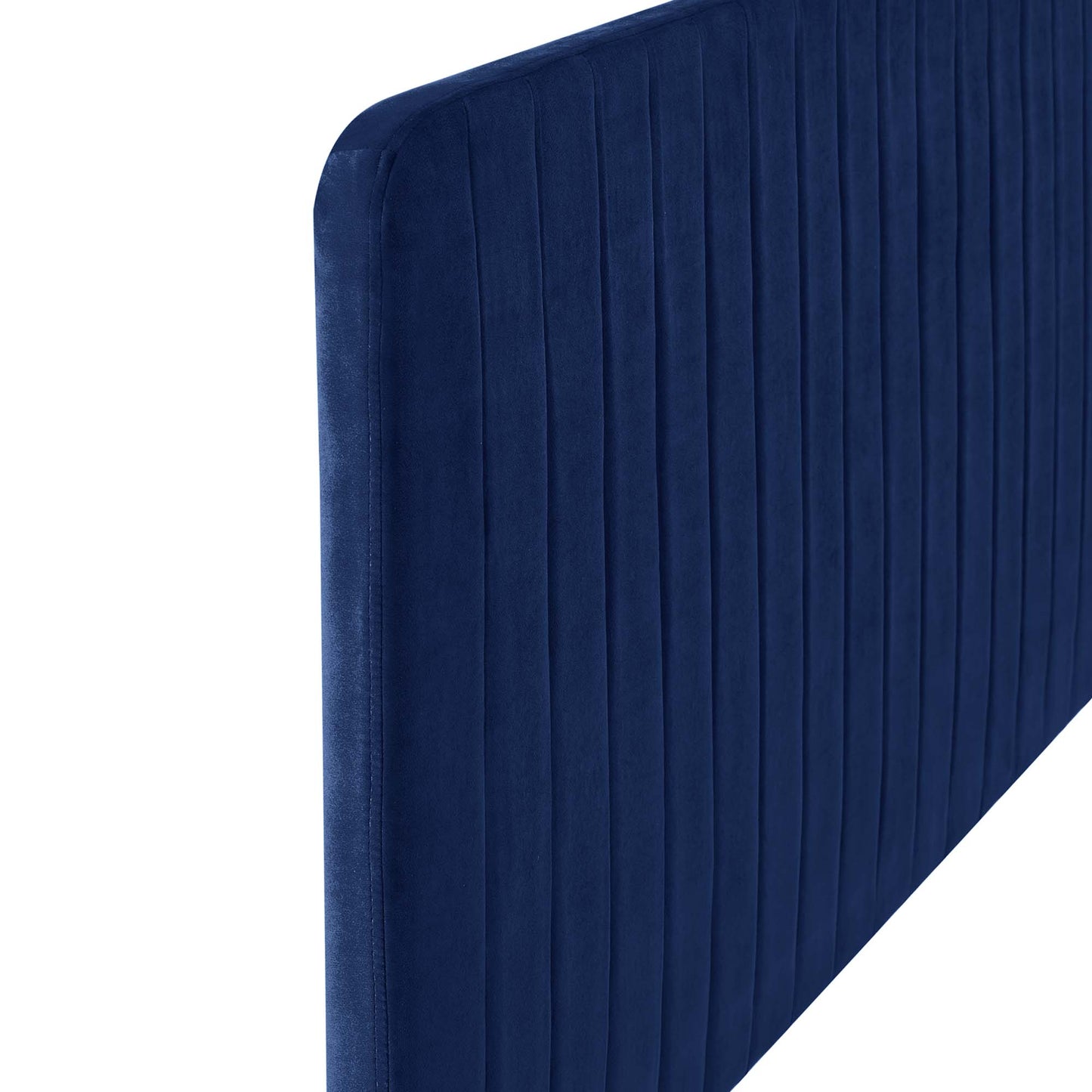 Plush navy velvet headboard with vertical channel tufting and rounded corner.